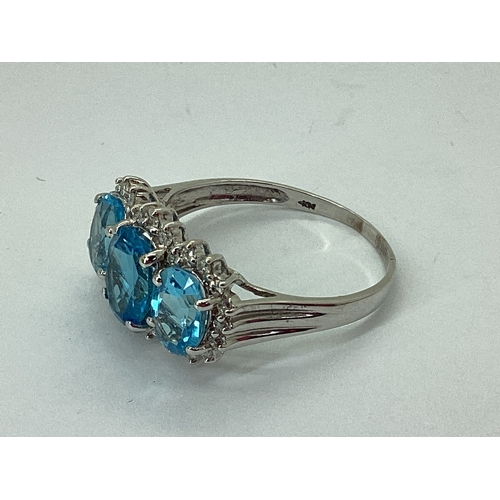 71 - A Blue Topaz and Diamond Triple Cluster Ring, claw set throughout, between reeded shoulders, indisti... 