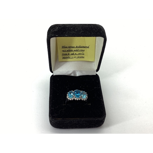 71 - A Blue Topaz and Diamond Triple Cluster Ring, claw set throughout, between reeded shoulders, indisti... 