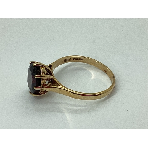 75 - A 9ct Gold Garnet Single Stone Dress Ring, oval claw set high between plain shoulders (finger size Q... 