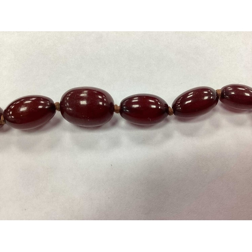 207 - A Vintage Cherry Amber Colour Single Strand Bead Necklace, together with a polished garnet bead neck... 