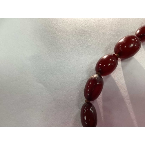 207 - A Vintage Cherry Amber Colour Single Strand Bead Necklace, together with a polished garnet bead neck... 