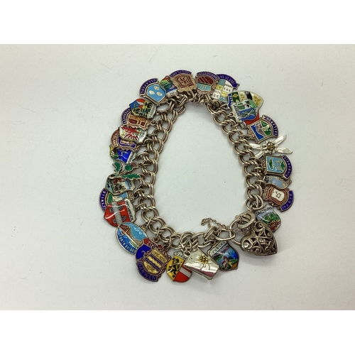 107 - A Double Curb Link Charm Bracelet, to openwork heart shape padlock style clasp, suspending numerous ... 