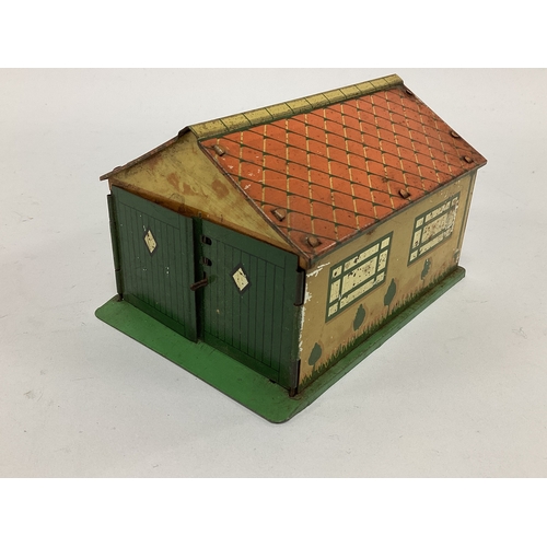 876 - A pre-war tinplate Dinky garage complete with two opening doors. Overall signs of wear.