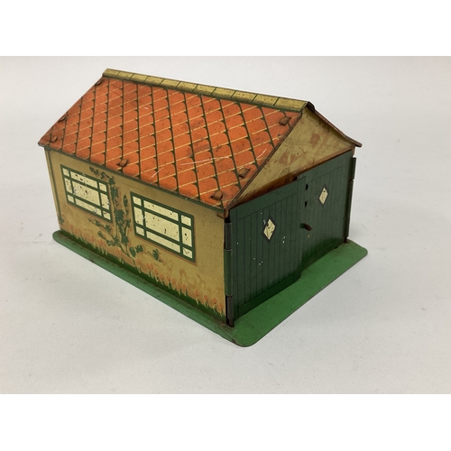 876 - A pre-war tinplate Dinky garage complete with two opening doors. Overall signs of wear.