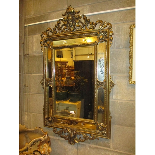 560 - Ornate Gilt Frame Wall Mirror having a Portrait Crest, 129x78cm