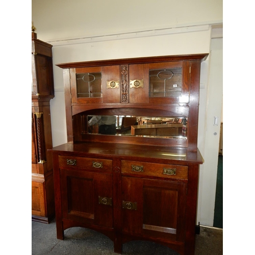 107 - An Arts and Crafts oak sideboard, the raised back fitted two leaded glass doors, ornate brass back p... 