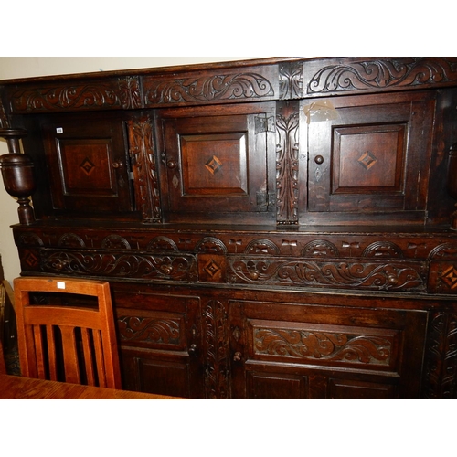 113 - An antique oak court cupboard, the upper part fitted three doors with inlaid decoration, baluster tu... 