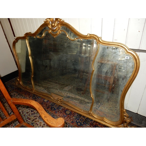 115 - A large gilt framed triple mirror with leaf scroll pediment and shelf - 94in. wide and 50in. high