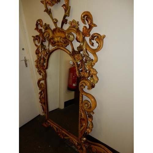 120 - An Italian mirror with rose and leaf scroll decorated frame, complete with shelf and bird and leaf s... 