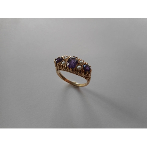 237 - A lady's Victorian style ring set three amethysts and four half pearl spacers, on a 9ct. gold shank