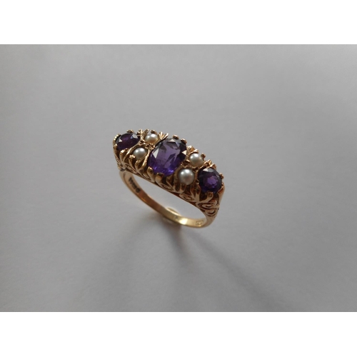 237 - A lady's Victorian style ring set three amethysts and four half pearl spacers, on a 9ct. gold shank