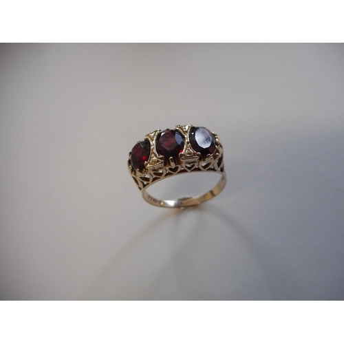 242 - A lady's Victorian style ring set three garnets, on a 9ct. gold shank