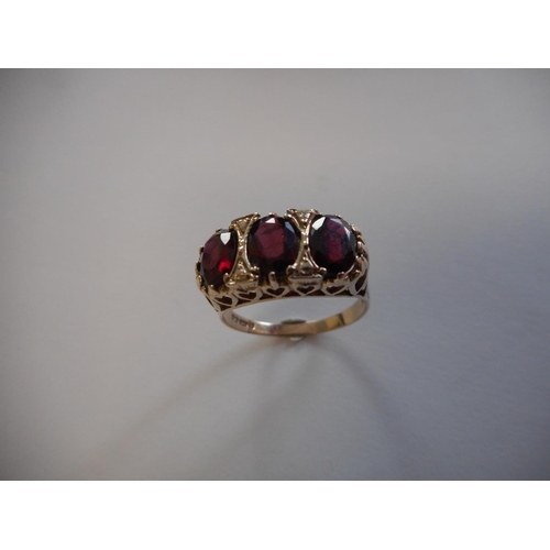 242 - A lady's Victorian style ring set three garnets, on a 9ct. gold shank