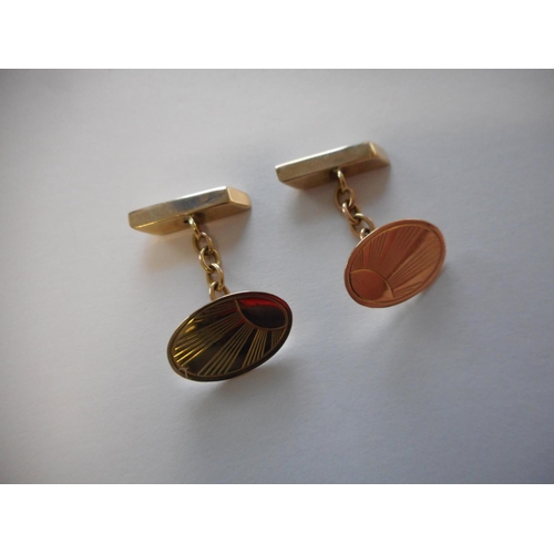 248 - A pair of 9ct. gold cufflinks with sunray decoration to the oval fronts