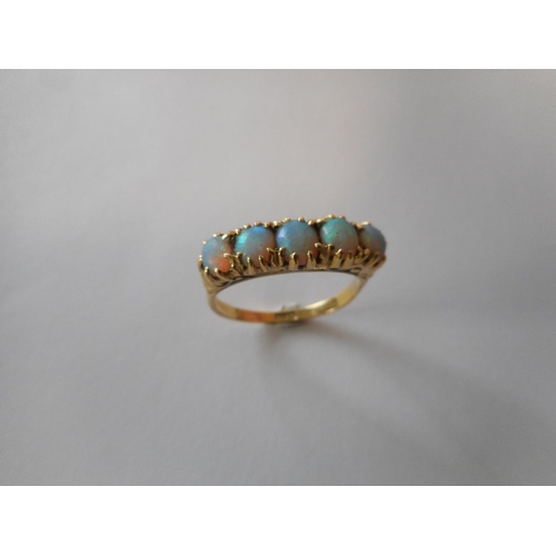 254 - A lady's ring set five graduated opals, on an 18ct. gold shank