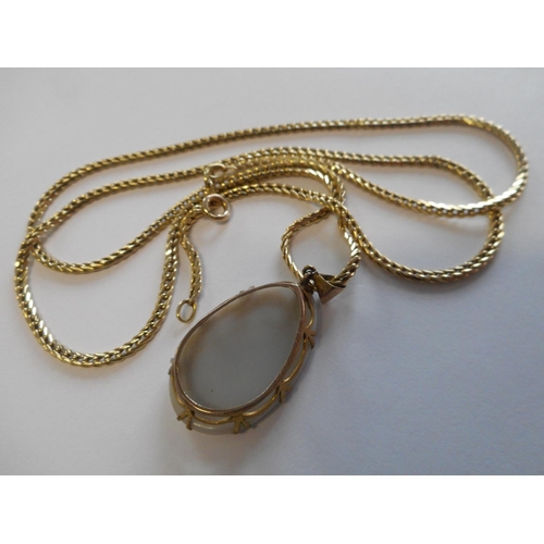 255 - A lady's opal pendant in a gold coloured metal frame on a 14kt. gold chain