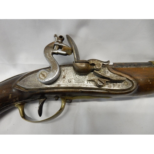 298 - A flintlock pistol with brass mounts, marked with a crown and GR to the lock - 16in. long