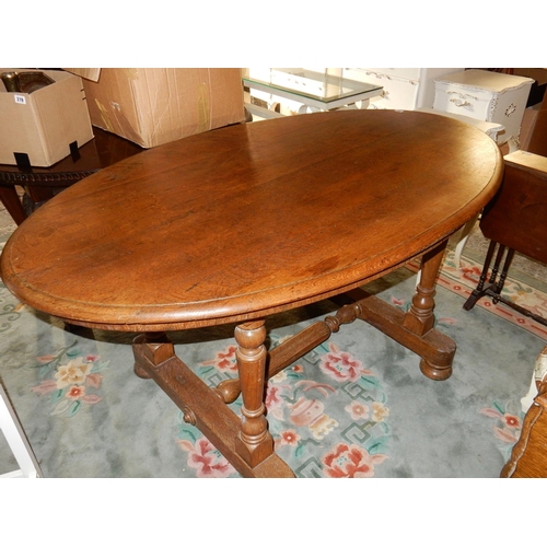 53 - An oak dining table with oval top, on turned legs - 60in. x 36in.