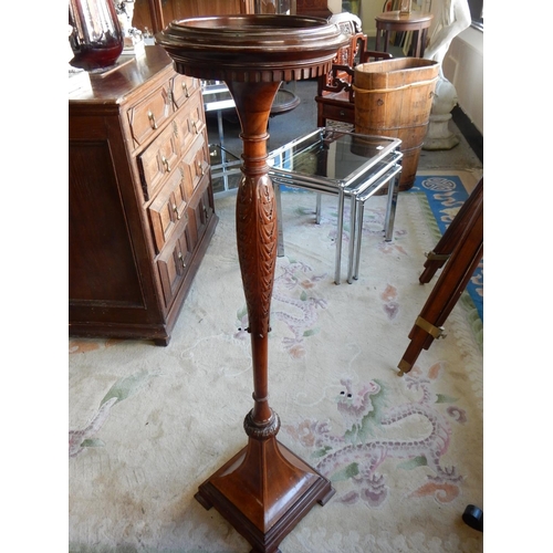 82 - A mahogany and inlaid torchere with circular top, dentil frieze, on leaf carved baluster column, tap... 