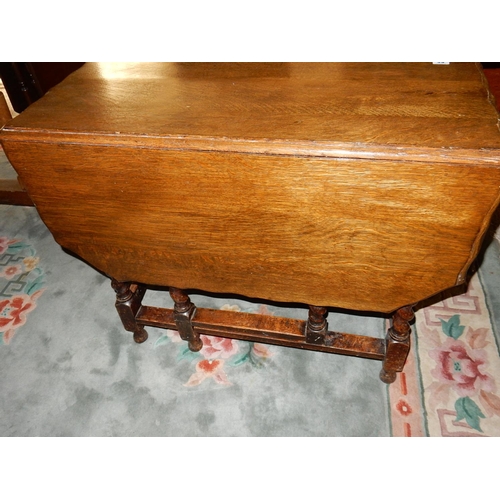 88 - An oak gateleg table fitted two shaped drop flaps, on barley twist legs united by straight stretcher... 