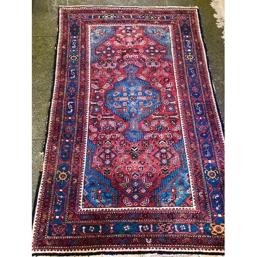 1 - An Eastern rug, red field with repeating red, white and blue stylised flowers, cream and floral mult... 