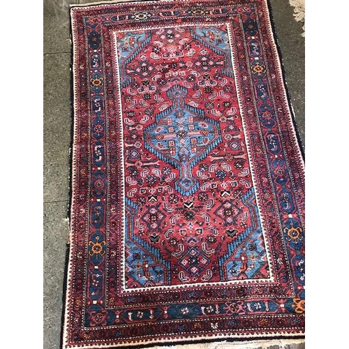 1 - An Eastern rug, red field with repeating red, white and blue stylised flowers, cream and floral mult... 