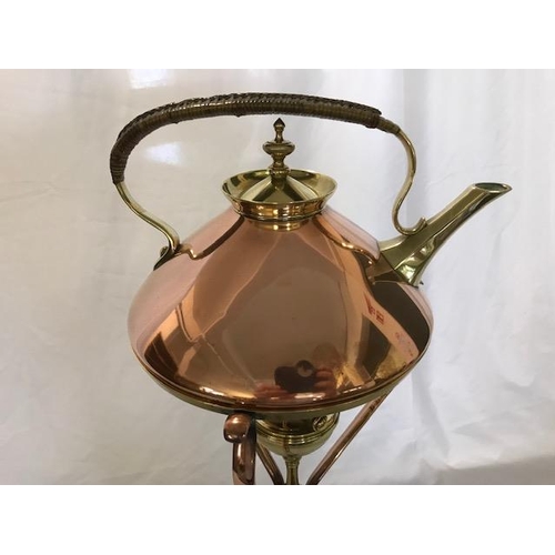 266 - A Benson brass and copper tea kettle with wicker covered handle, on a matching stand with burner, on... 