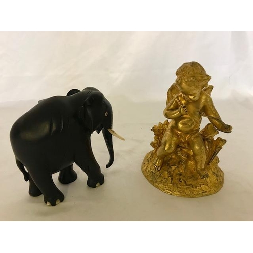 269 - A 19th Century gilded bronze cupid - 6 1/2in. high and an ebony elephant