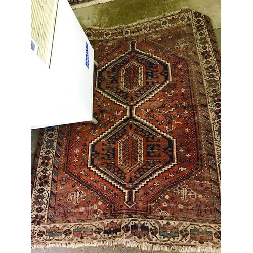 3 - An Eastern rug, red field with stylised blue and orange centre, multi bordered, fringed