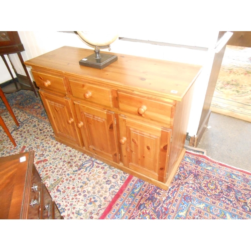 40 - A modern pine dresser base fitted three frieze drawers, cupboards under, on panelled base - 48in. wi... 