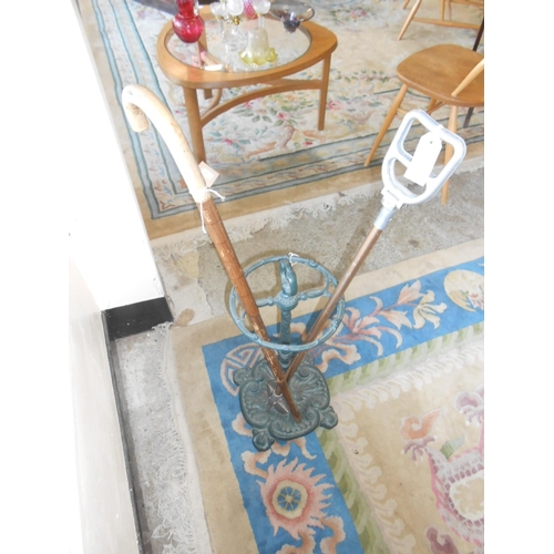 47 - A cast iron umbrella stand, an umbrella walking stick and a shooting stick