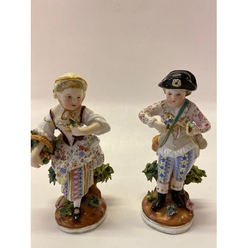 170 - A pair of Continental porcelain figures in floral dress, he holding two sprigs and she with a basket... 