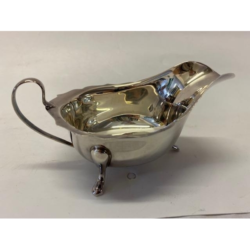 190 - A silver sauce boat with serpentine edge, on three feet - Sheffield 1966, makers marks for Viners