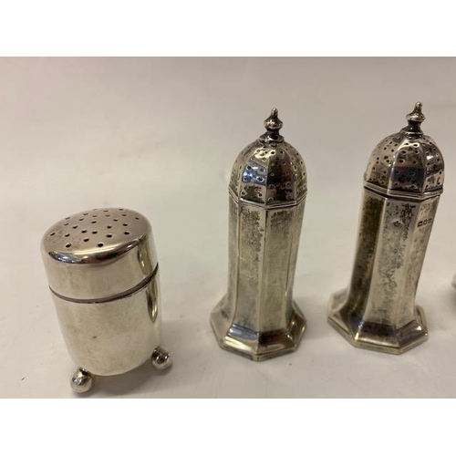 205 - A pair of panelled silver pepperettes - London 1917  and a pair of plain silver cylindrical pepperet... 