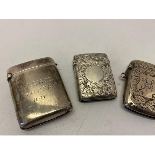 207 - Two silver vesta cases with engraved leaf scroll decoration and one other with inscription to the fr... 