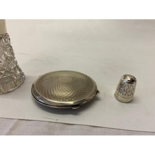 211 - An engine turned silver compact, a cut scent bottle with silver lid inset enamel lid and a silver th... 