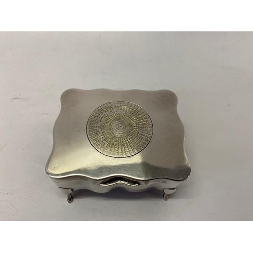 229 - A rectangular silver trinket box with inset circular engine turned decoration, on four short feet -