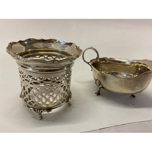 233 - A silver sauce boat with scroll handle, on three pad feet - Birmingham 1911 and a silver bottle fram... 