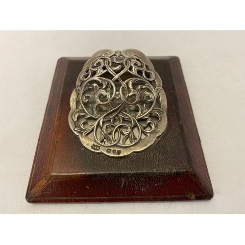 240 - A Victorian silver letter clip with pierced scroll decoration, on wooden base - London 1895, makers ... 