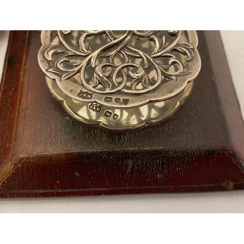 240 - A Victorian silver letter clip with pierced scroll decoration, on wooden base - London 1895, makers ... 