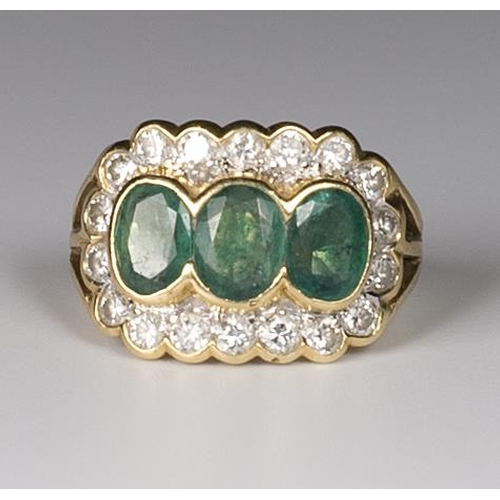 290 - A lady's ring set three oval emeralds surrounded by diamonds, on an 18kt. gold shank