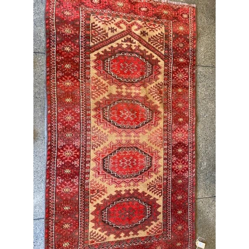 3 - An Eastern Bokhara style rug, cream and red centre with four medallions to the centre, multi bordere... 