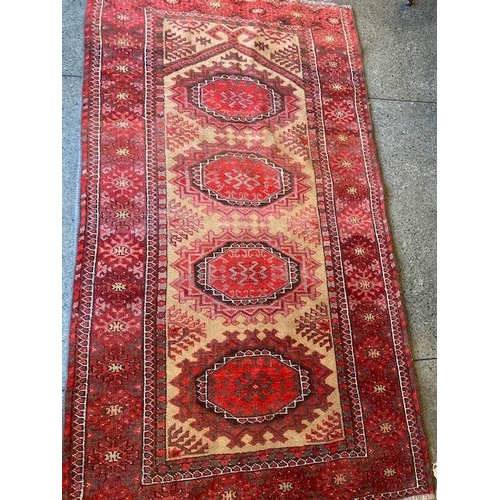 3 - An Eastern Bokhara style rug, cream and red centre with four medallions to the centre, multi bordere... 