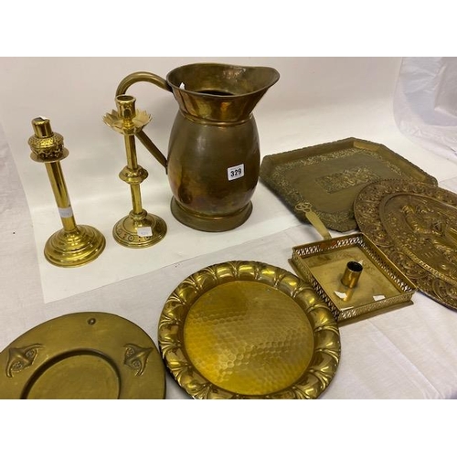 329 - A large brass jug, brass chamberstick, candlesticks etc..