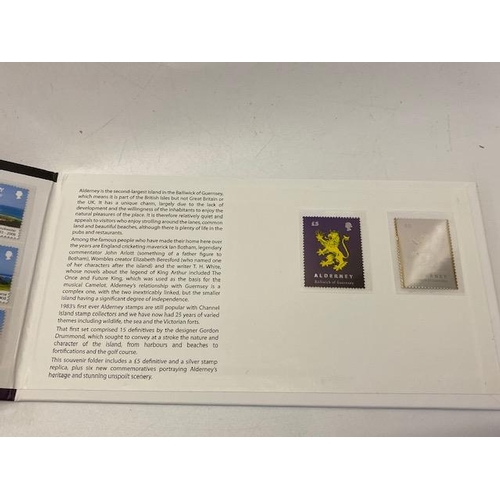 53 - An album of First Day covers and a replica silver stamp from Alderney