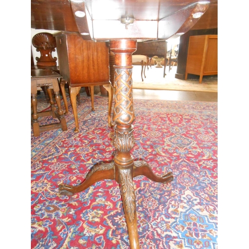 104 - A Georgian mahogany table with circular hinged top, on lattice carved centre column, three downswept... 