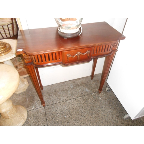 106 - A mahogany sidetable with bow front and applied swag decoration, on square tapered legs and spade fe... 