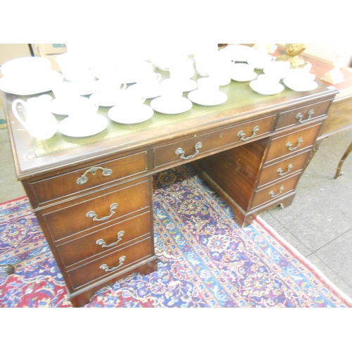 65 - A mahogany desk with green tooled leather writing surface, three frieze drawers and three drawers to... 