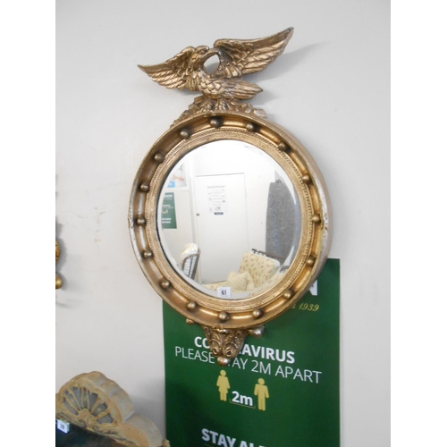 67 - A convex wall mirror in a Regency design frame with eagle surmount