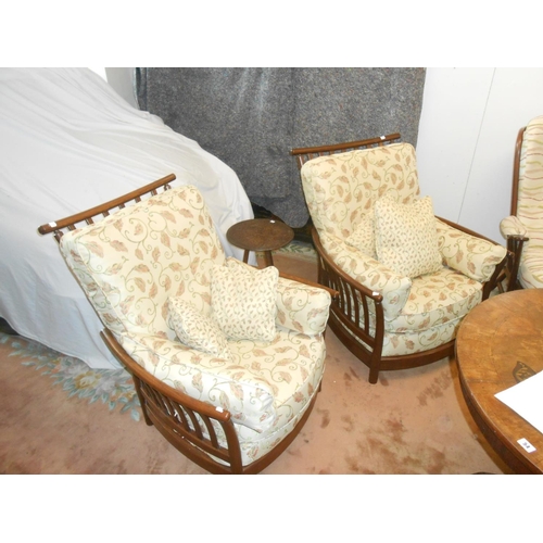 81 - A lady's modern dark elm armchair, a matching gentleman's armchair and an Ercol dark elm Evergreen p... 